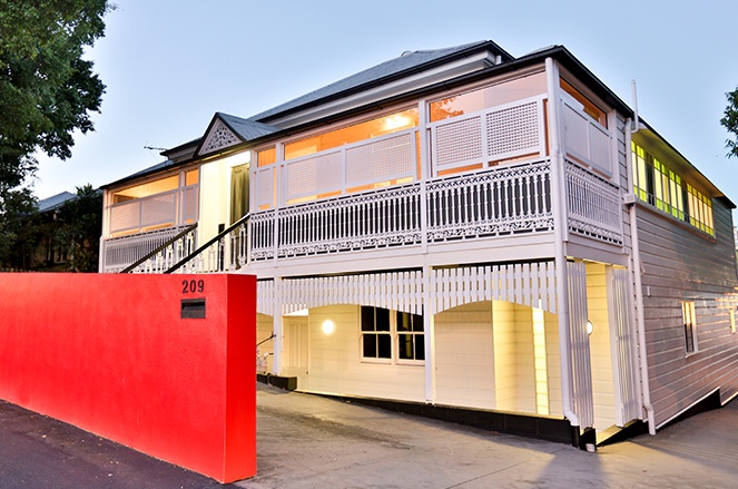painted Queenslander house with red wall at the front
